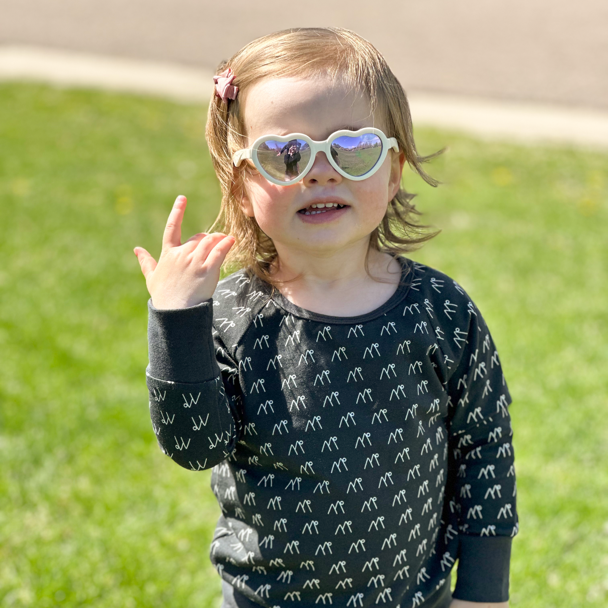 Child wearing long sleeve grey sweatshirt with mountains on it